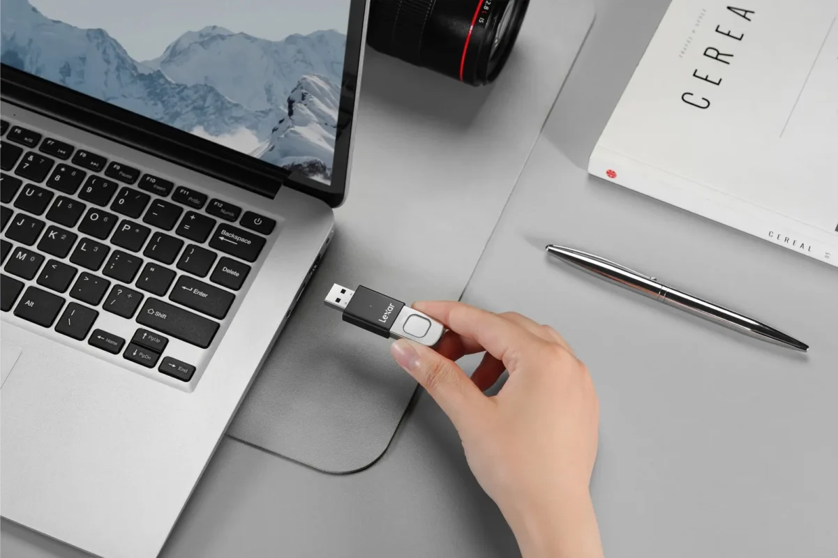 A hand plugging a USB stick into a laptop
