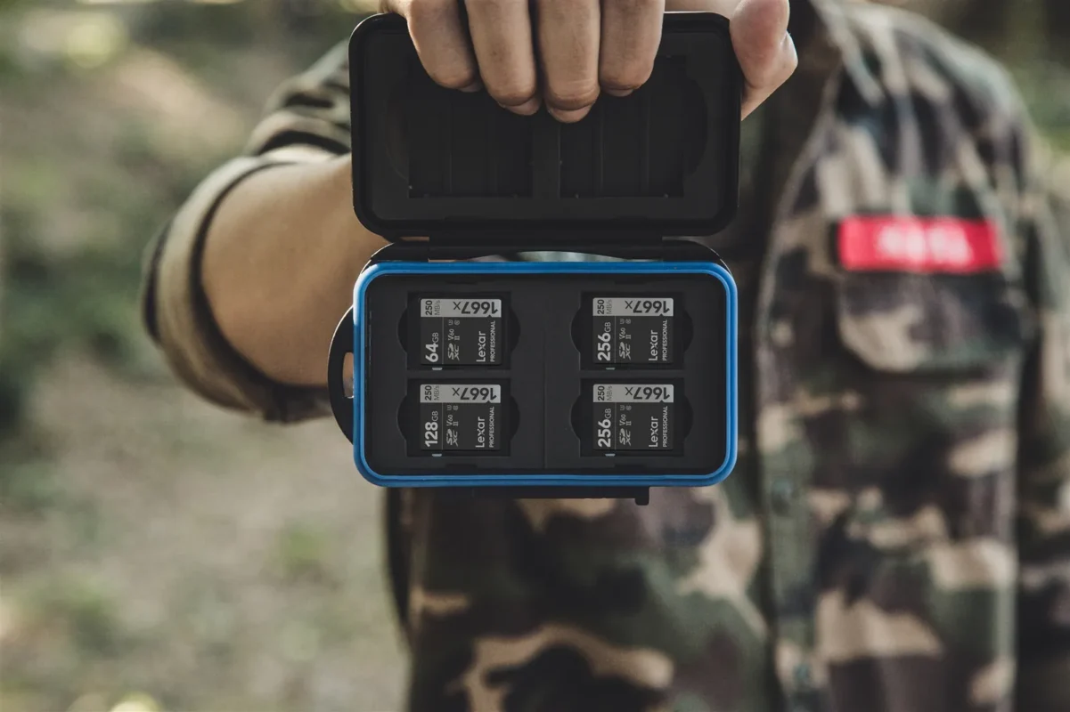 A card case full of SD cards held against a camouflage jacket