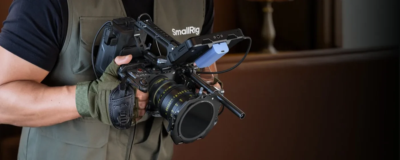 Operator with a caged cinema camera and a matte box in front of the lens