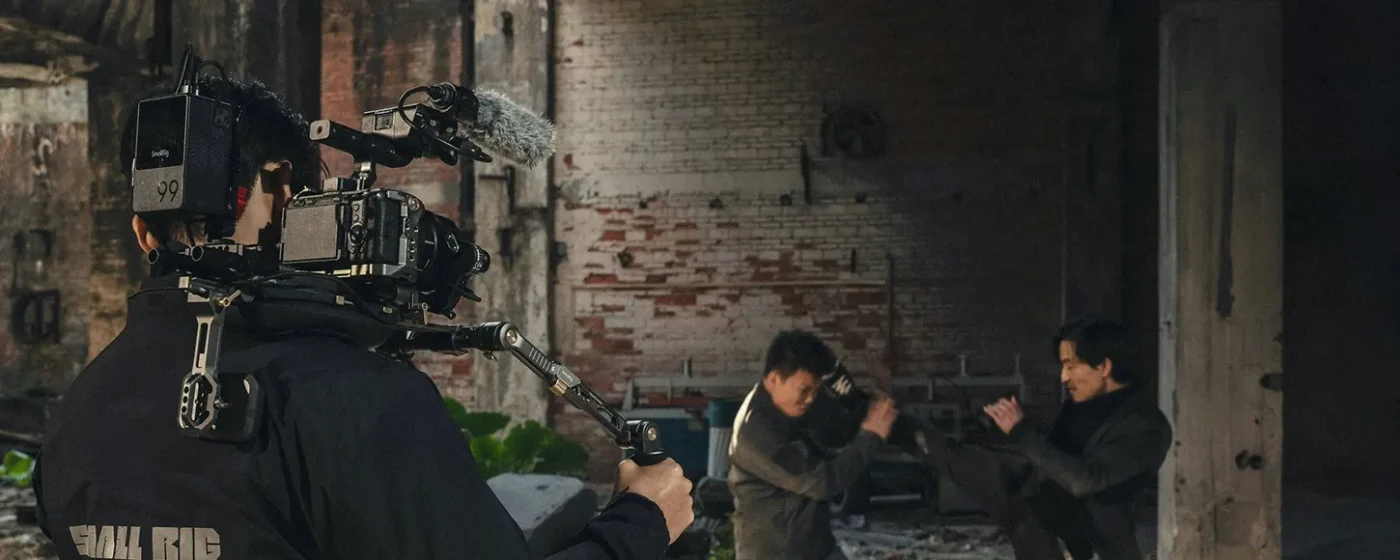 Operator walks a street with a camera on a shoulder rig
