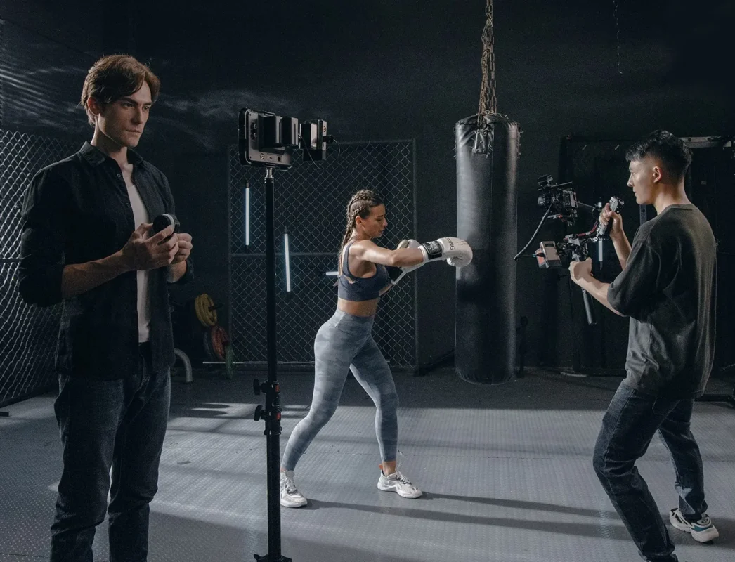 Focus puller turns a wireless follow focus during a shoot at a boxing gym