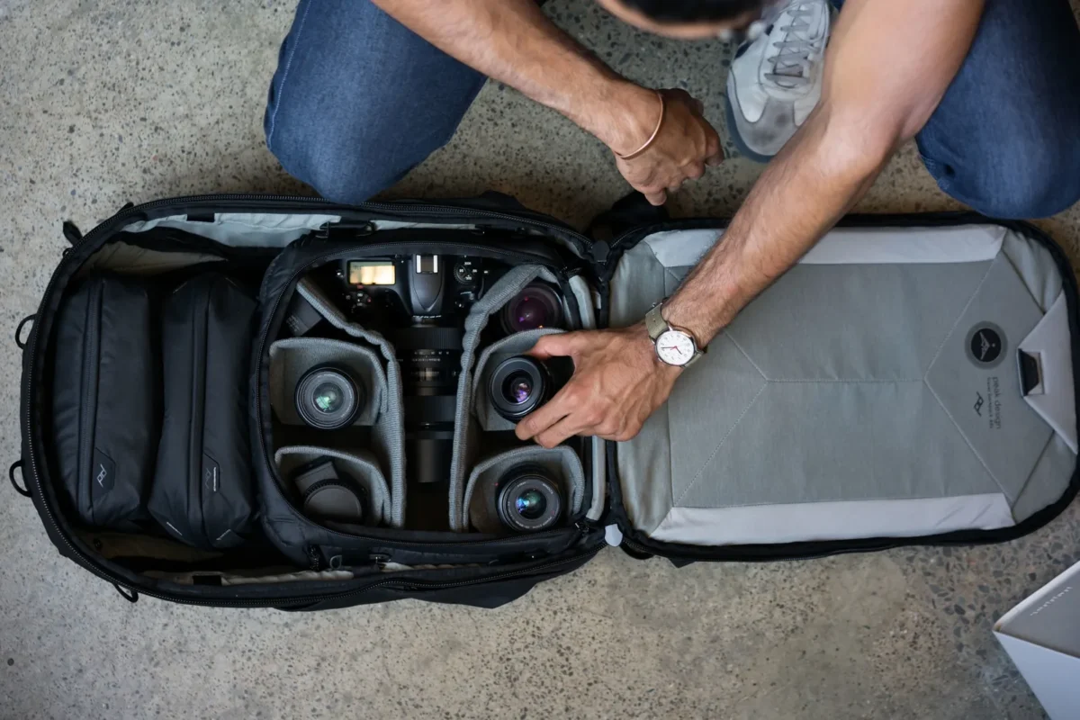 Kneeling photographer packing gear into a camera cube