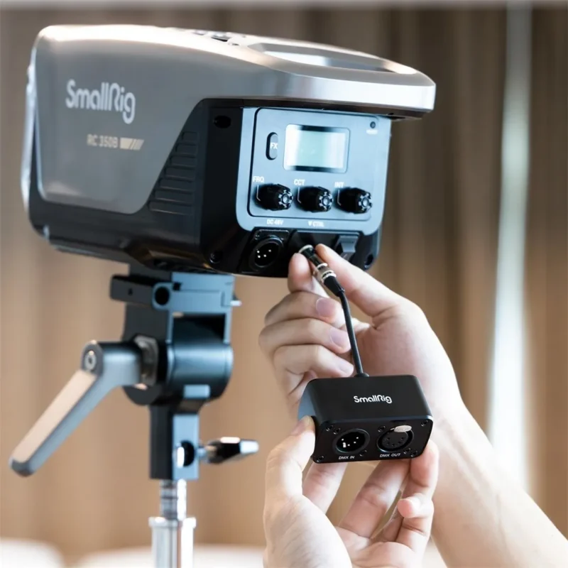 Hand adjusting a COB studio light mounted on a light stand