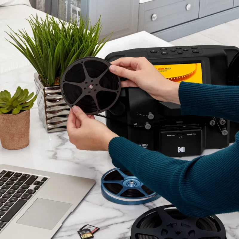 Hands loading film reels into a digitiser at home