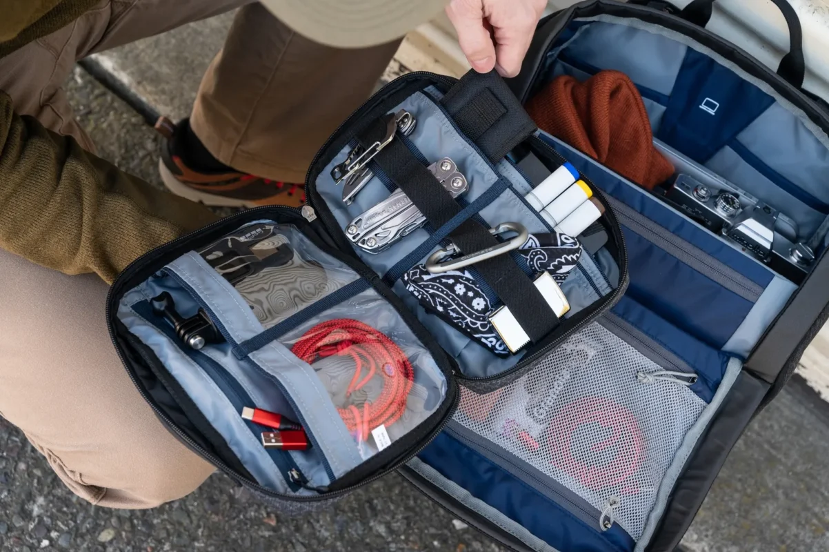 Hands sorting cables in an open tech pouch