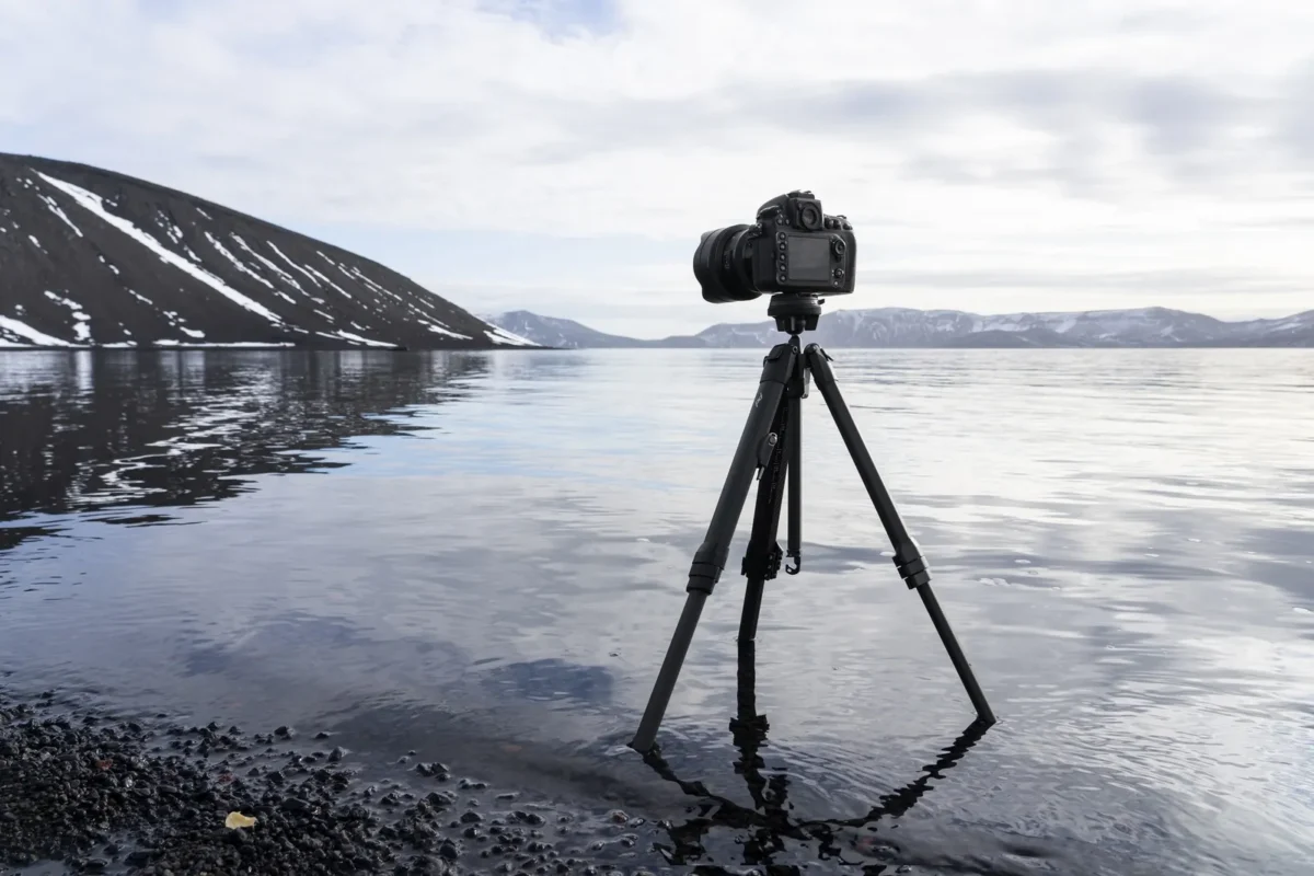 Camera on a travel tripod at the water's edge