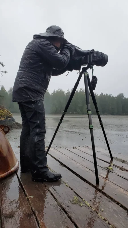 Camera on a tripod in heavy rain by a lake