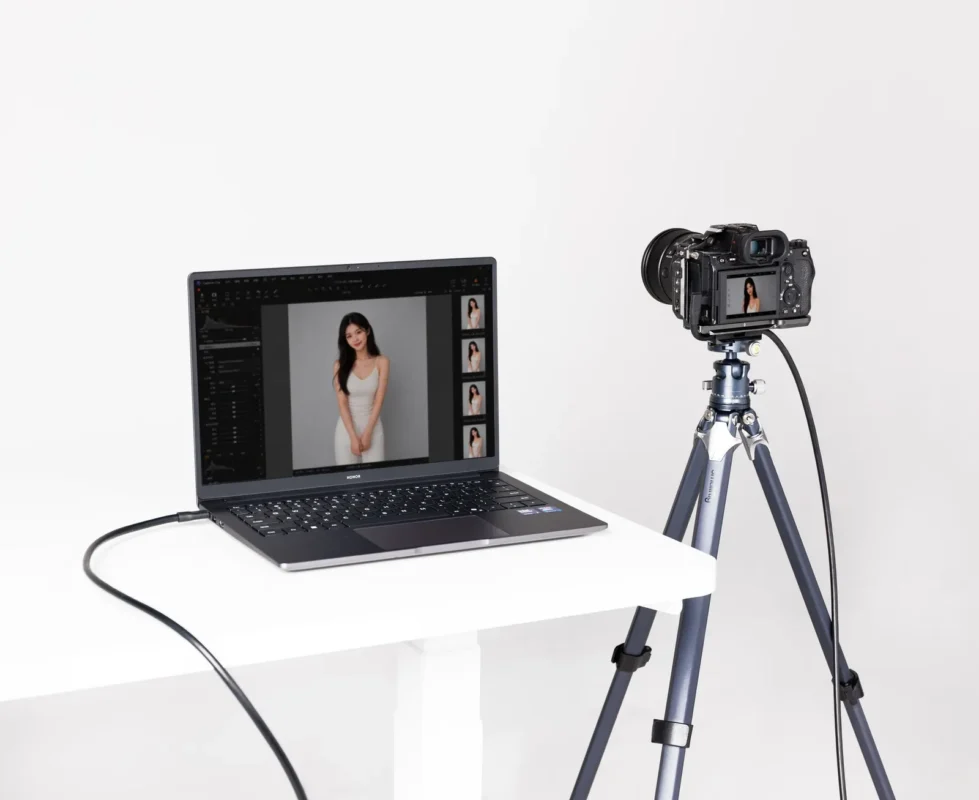 Camera on a tripod connected by cable to a laptop