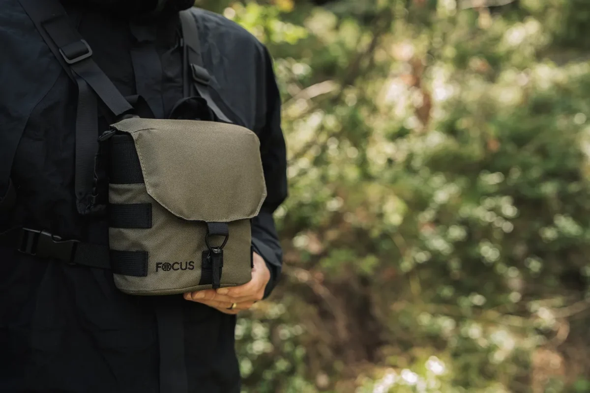 Binoculars in a chest harness on a hiker