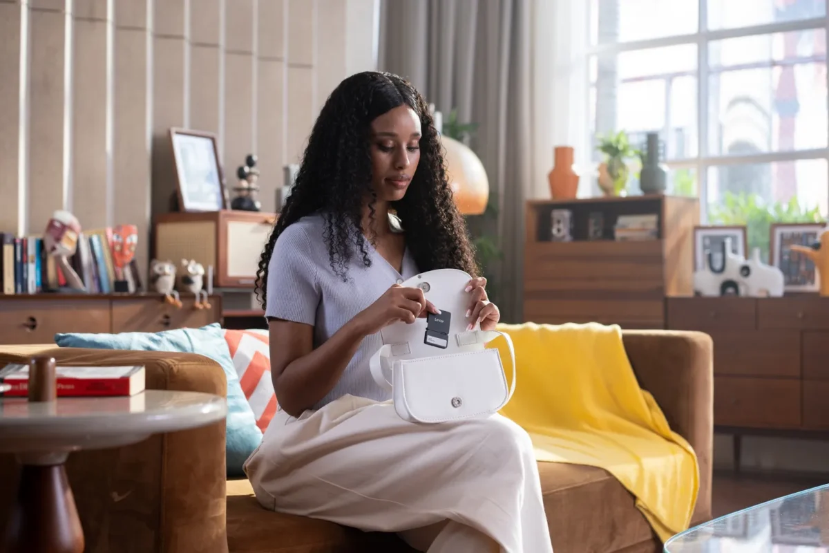Woman on a sofa backing up her phone to a portable SSD