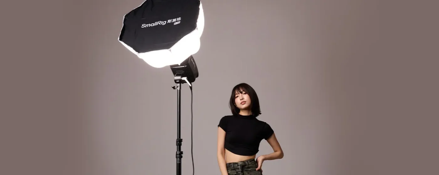 Woman posing under a large octagonal softbox in a studio