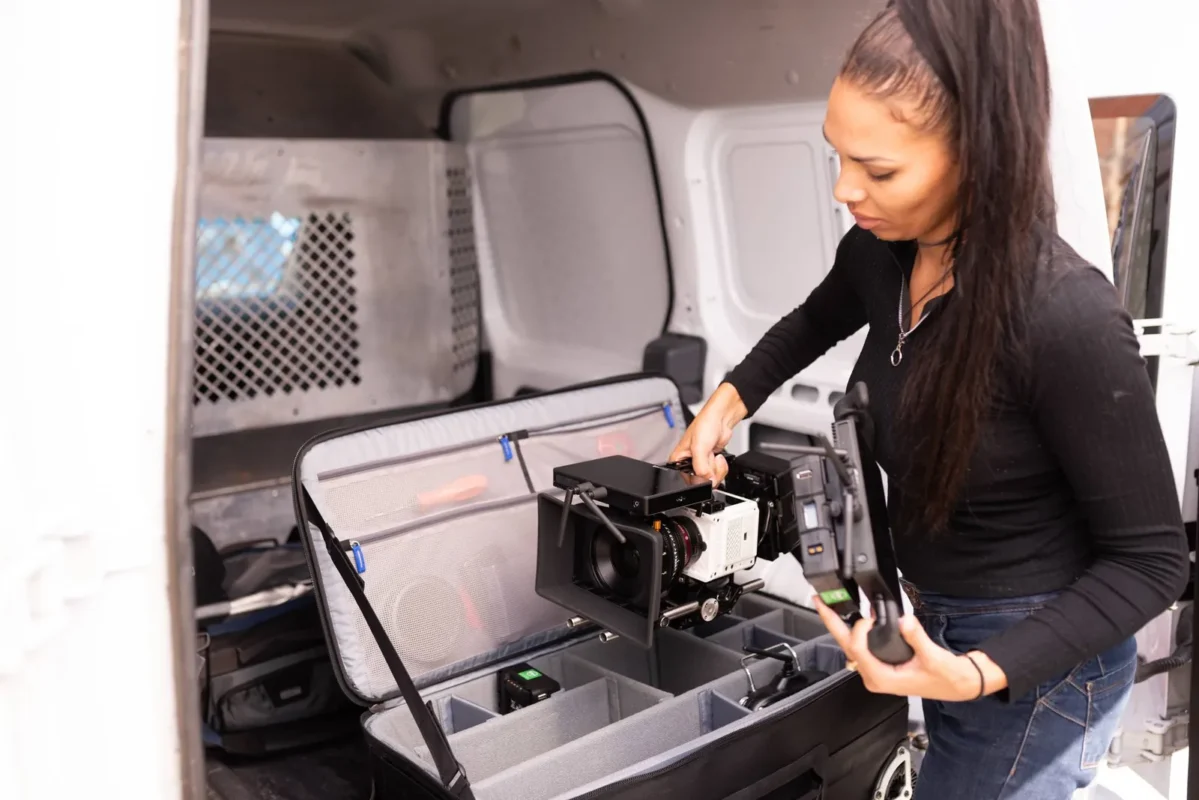 Woman loading a rolling case into a van