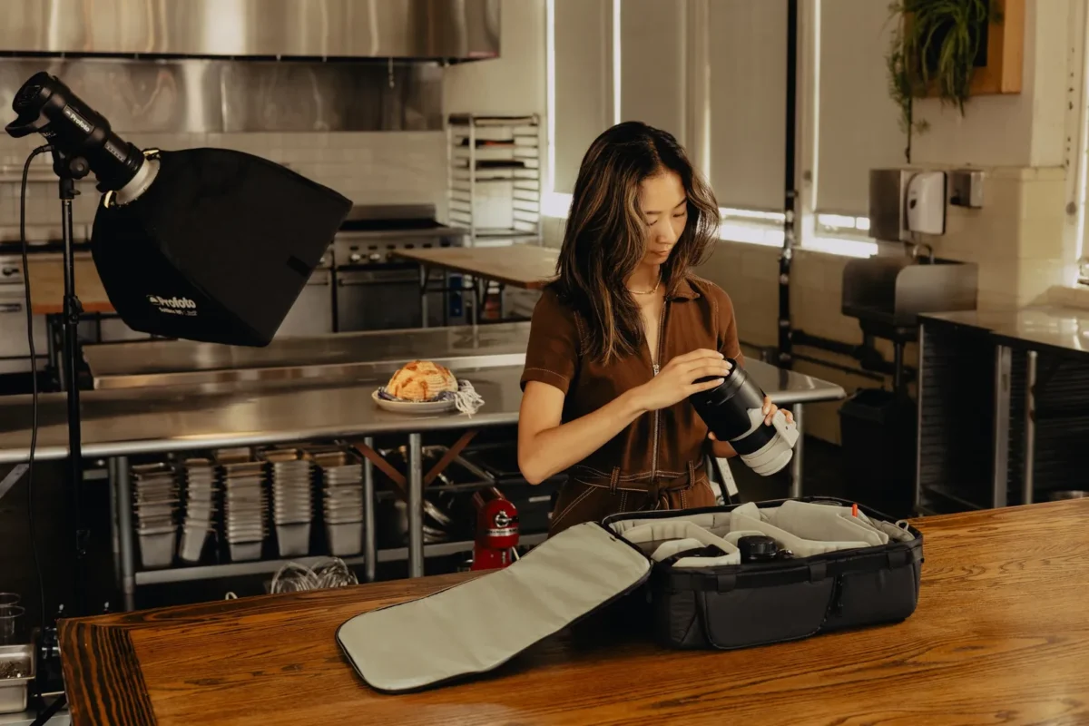 Woman packing camera gear into an insert at home