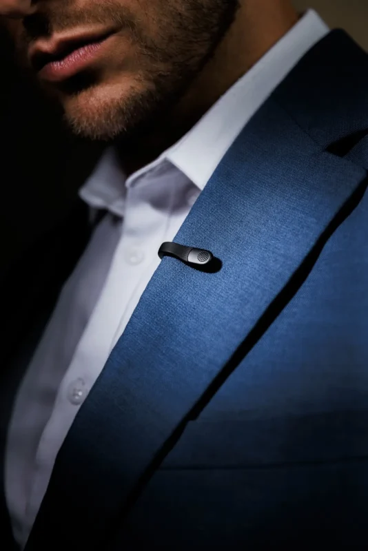 Small microphone clipped to the lapel of a navy suit