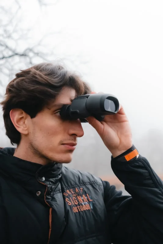Close-up of a man looking through small binoculars