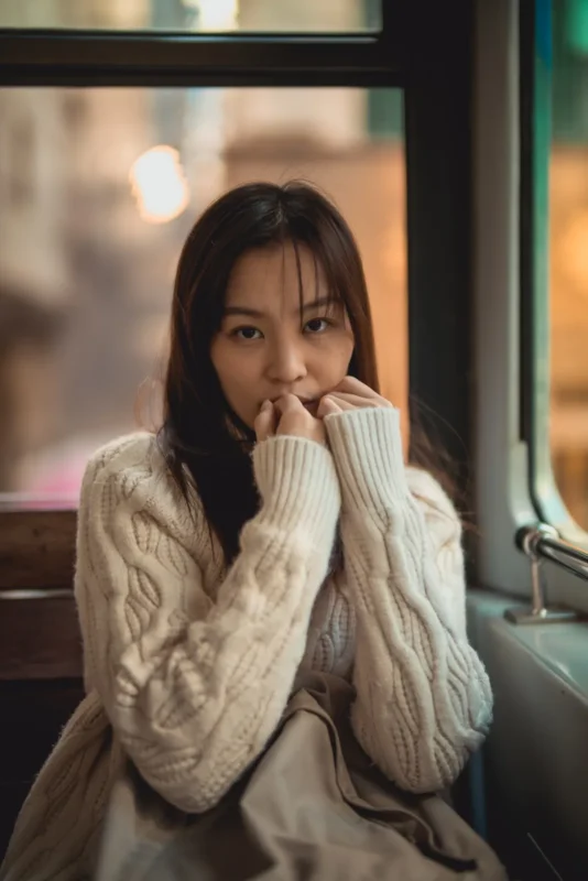 Portrait of a woman in a cream knit jumper with a softly blurred background