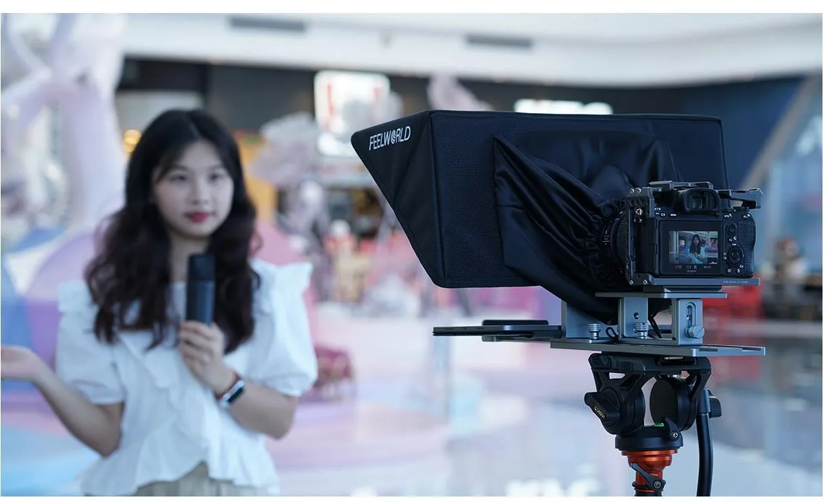 Presenter speaking to a camera through a teleprompter in a shopping centre
