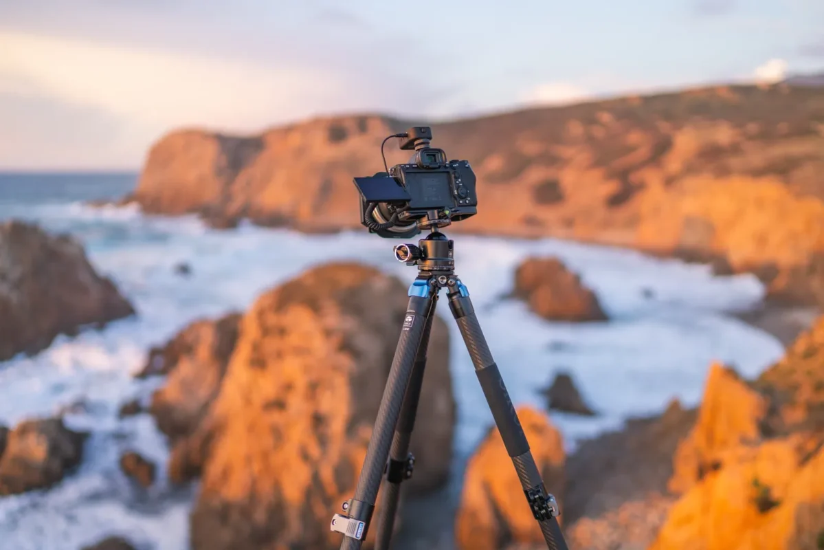 Tripod with a camera on coastal cliffs at sunset