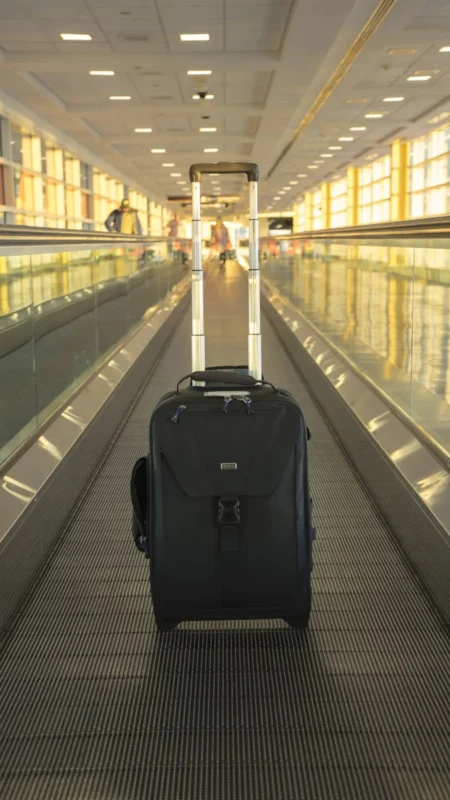 Black rolling camera bag on an airport walkway