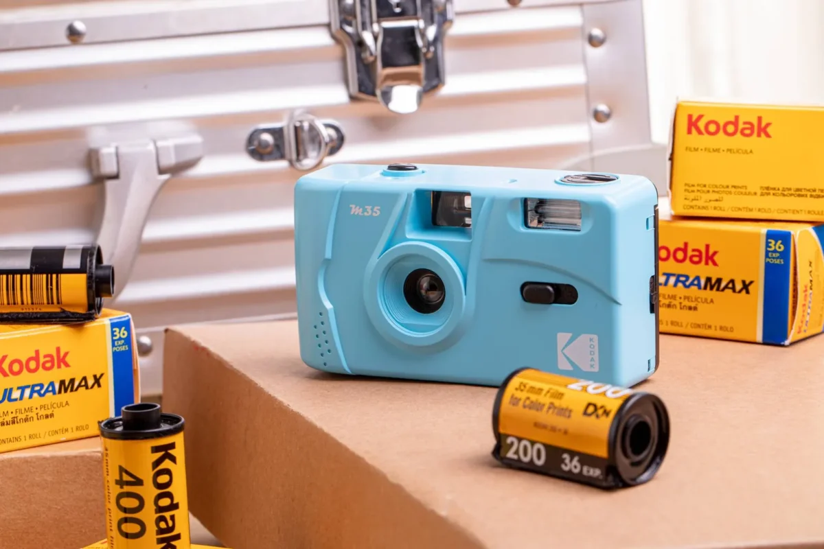 Turquoise film camera and rolls of film on a desk