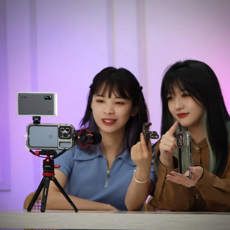 Two people filming themselves with a phone and an LED light
