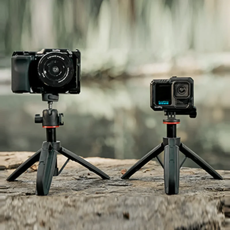 Two small cameras on mini tripods on a stone ledge