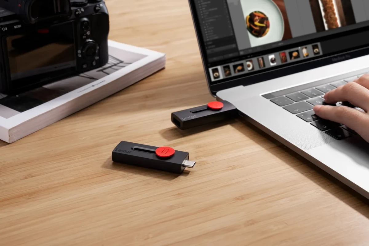 USB stick beside a laptop showing a photo edit