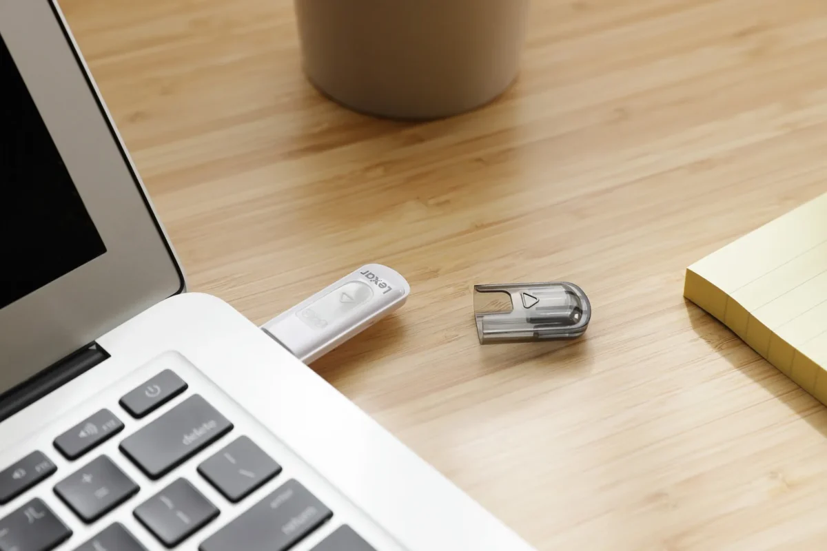 USB stick in a laptop next to sticky notes on a wooden desk