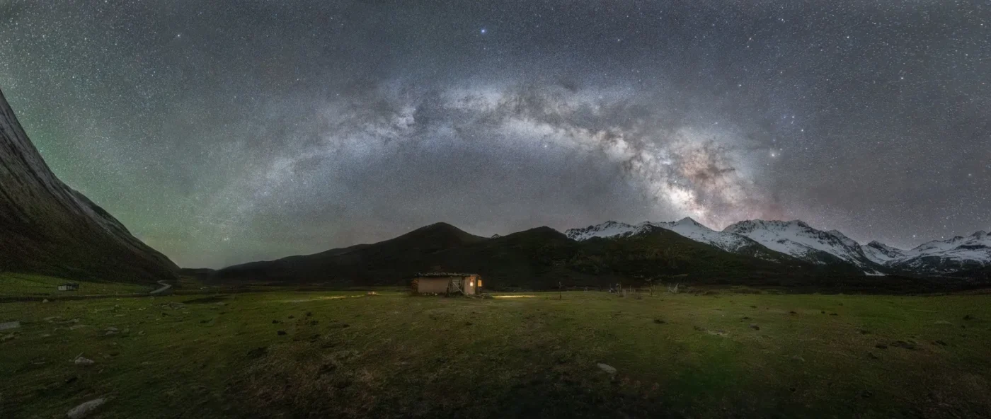 The Milky Way arching over dark hills